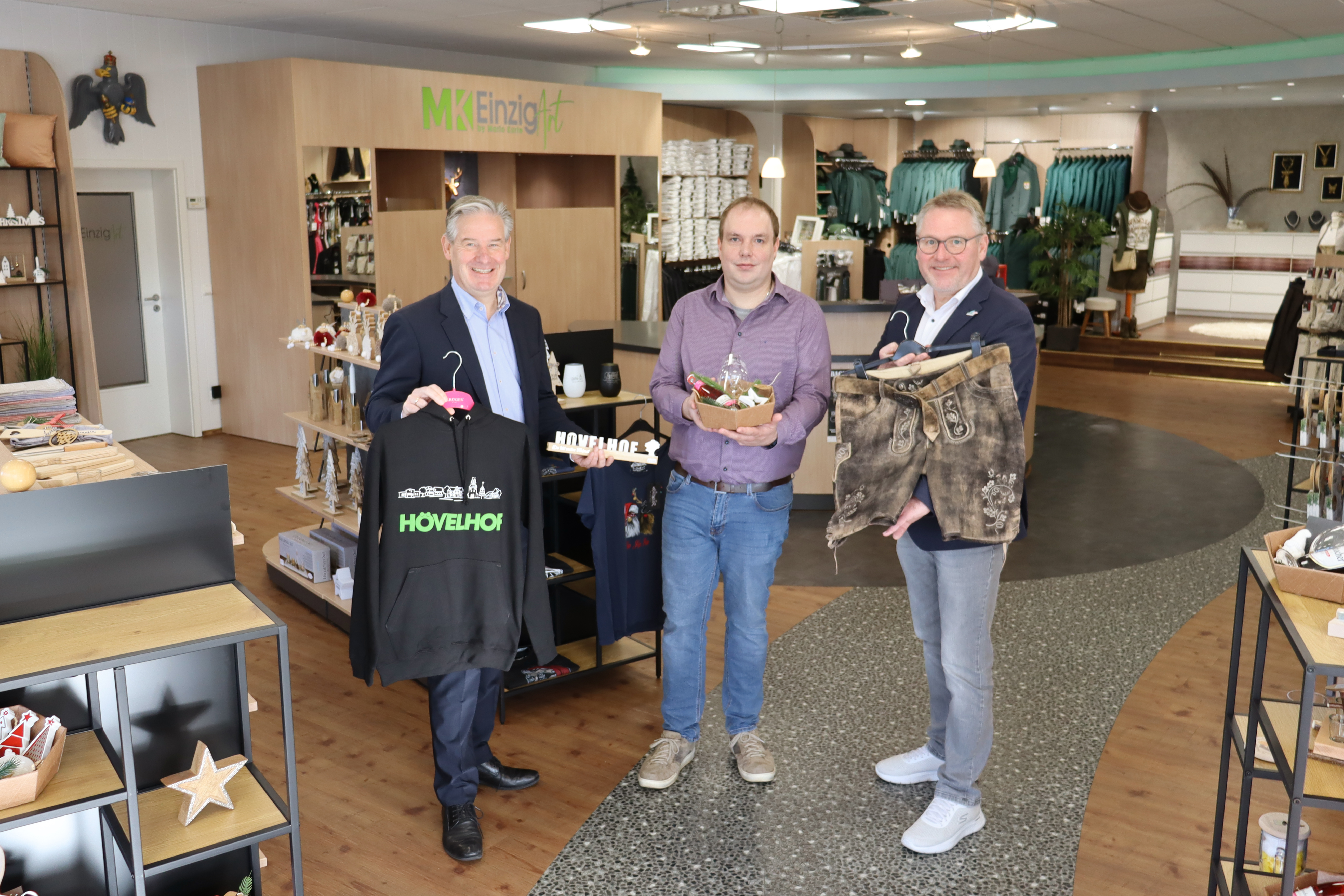 B�rgermeister Michael Berens, Inhaber Mario Kurte und Wirtschaftsf�rderer Thomas Westhof pr�sentieren eine Auswahl der vielen individuellen Produkte von EinzigArt